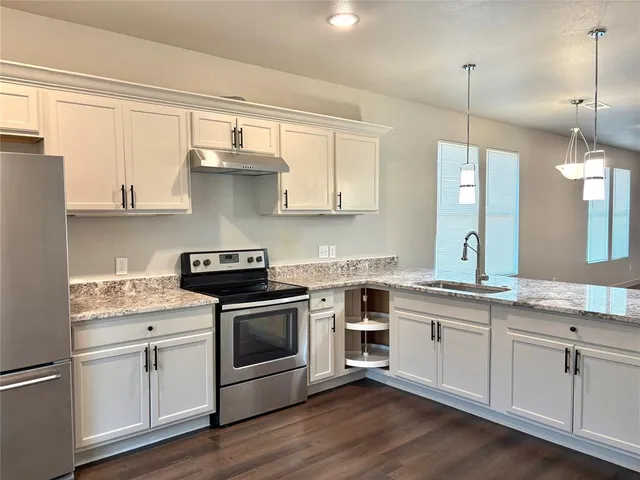 a kitchen with a stove sink and cabinets