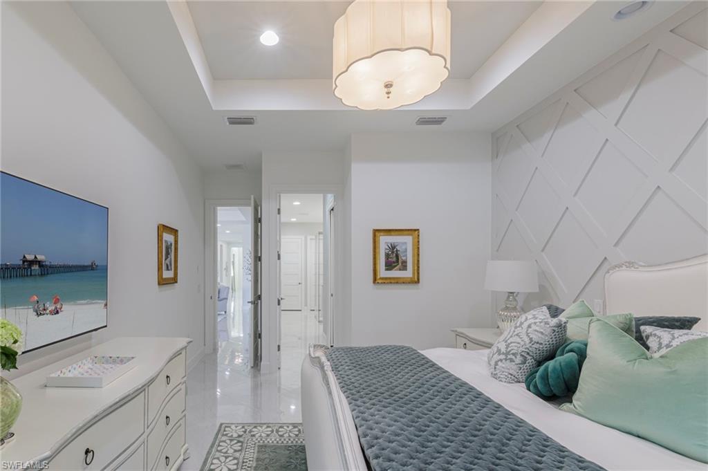 8963 Gustavia Court Naples, FL 34113 - Photo 12 of 47 a spacious bathroom with a granite countertop sink and a mirror