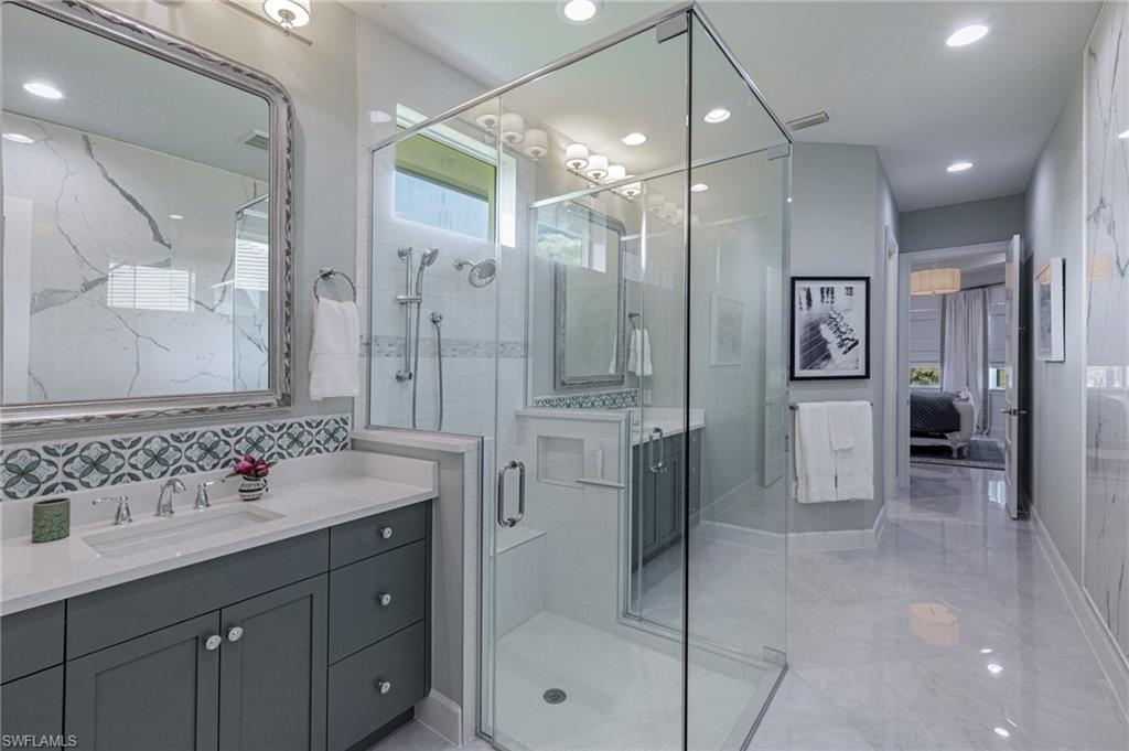 8963 Gustavia Court Naples, FL 34113 - Photo 15 of 47 a bathroom with a shower sink double and mirror