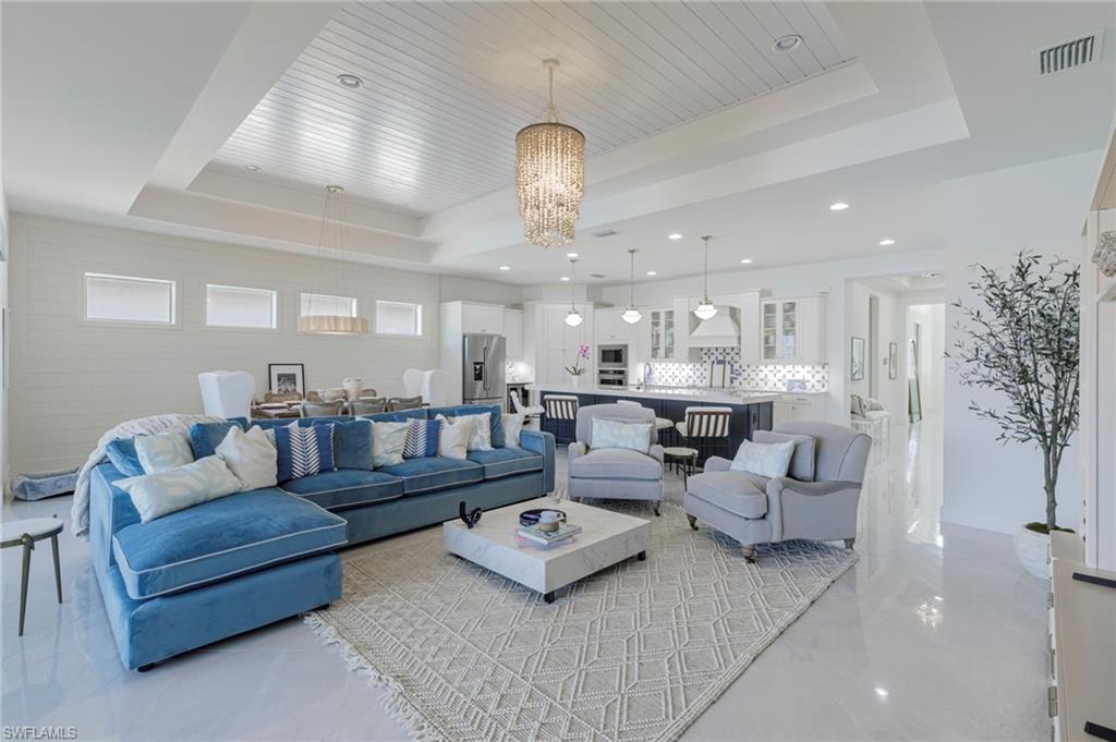 8963 Gustavia Court Naples, FL 34113 - Photo 16 of 47 a living room with furniture kitchen view and a chandelier