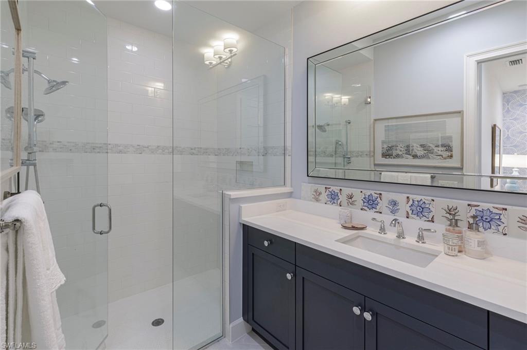 8963 Gustavia Court Naples, FL 34113 - Photo 22 of 47 a bathroom with a sink shower and a mirror