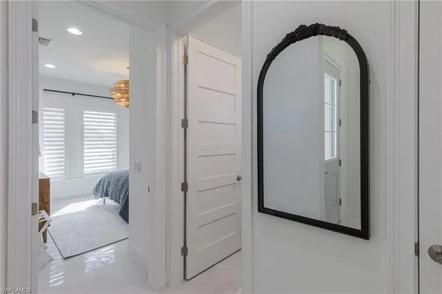 a bedroom with a bed and a lamp on dresser