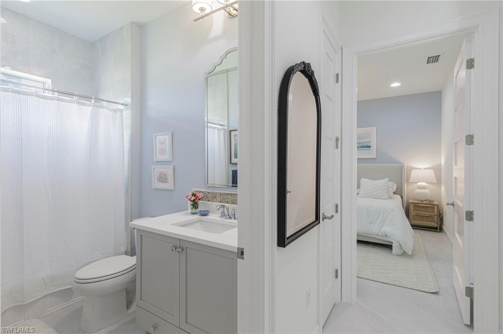 8963 Gustavia Court Naples, FL 34113 - Photo 26 of 47 a bathroom with a sink and a mirror