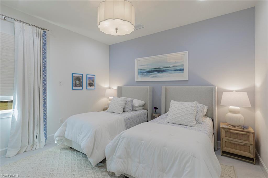8963 Gustavia Court Naples, FL 34113 - Photo 27 of 47 a bedroom with two beds and painting on the wall