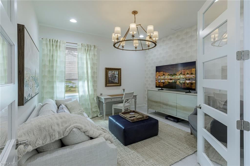 8963 Gustavia Court Naples, FL 34113 - Photo 29 of 47 a living room with furniture and a flat screen tv