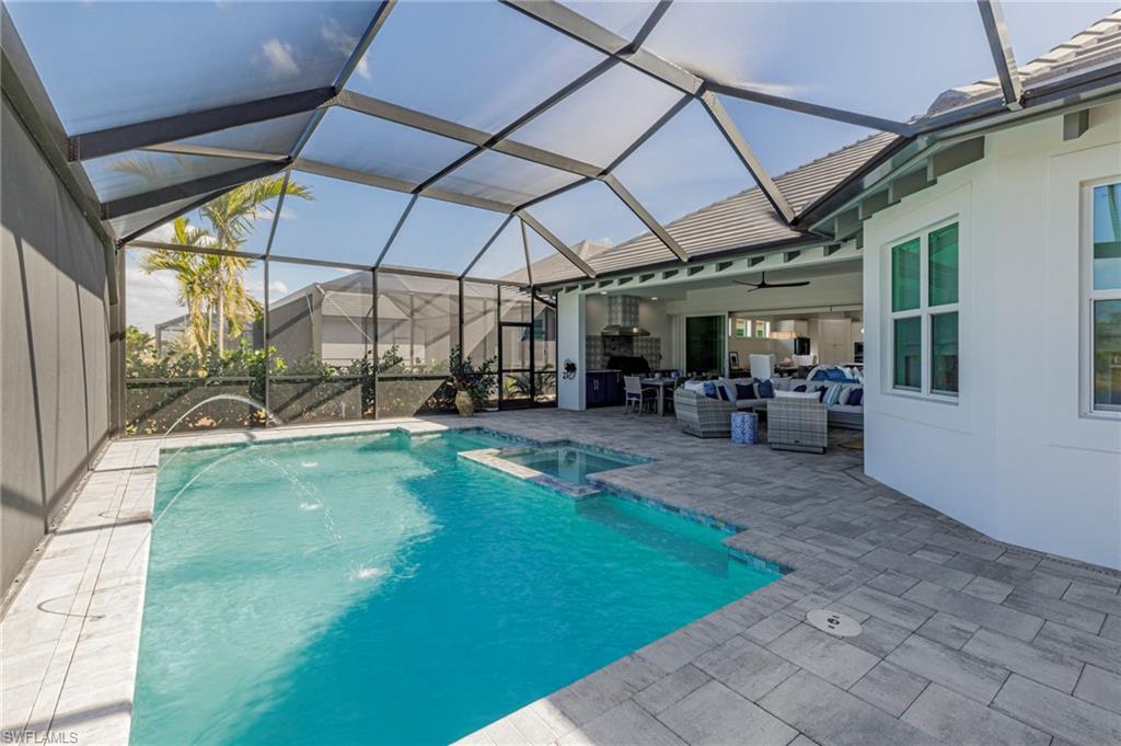 8963 Gustavia Court Naples, FL 34113 - Photo 7 of 47 a view of a backyard with table and chairs under an umbrella