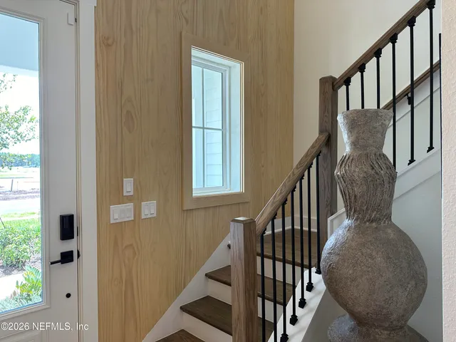 a view of staircase with lots of frames on wall and windows