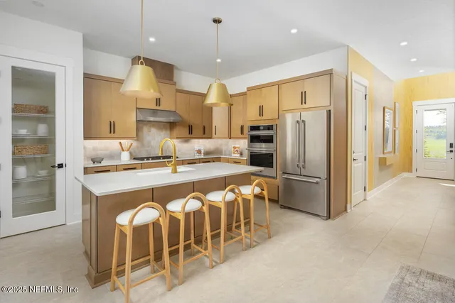 a kitchen with stainless steel appliances granite countertop a sink refrigerator and cabinets
