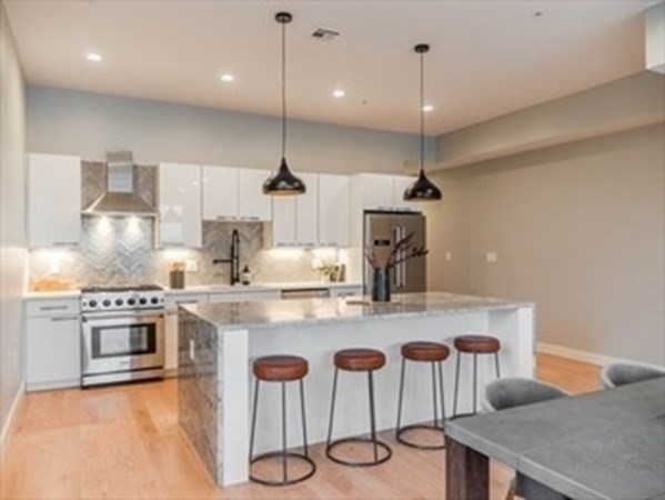 a kitchen with stainless steel appliances granite countertop a sink a stove a refrigerator and island