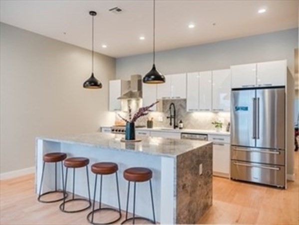 243 Condor Street, Unit 3 Boston, MA 02128 - Photo 2 of 16 a kitchen with kitchen island a counter space a sink appliances and cabinets