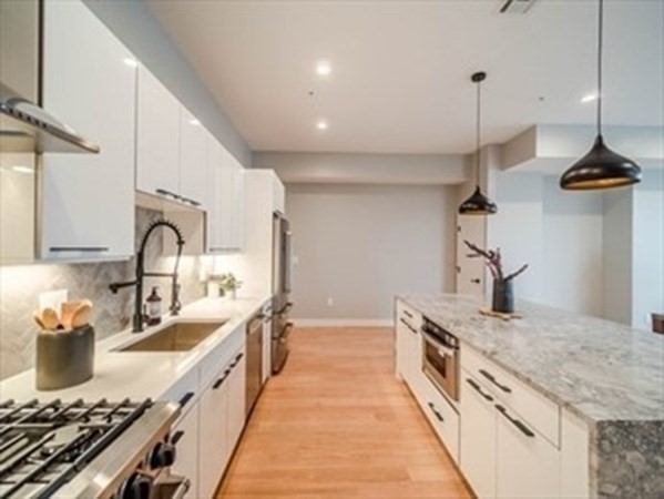 243 Condor Street, Unit 3 Boston, MA 02128 - Photo 4 of 16 a kitchen with granite countertop a sink stainless steel appliances and cabinets
