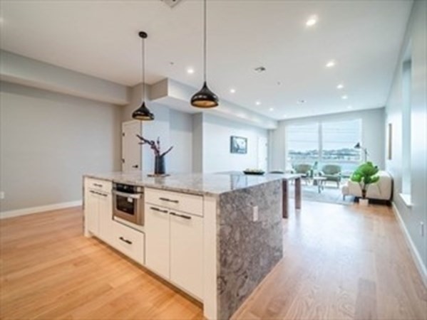 243 Condor Street, Unit 3 Boston, MA 02128 - Photo 5 of 16 a kitchen with stainless steel appliances granite countertop a stove and a wooden floors