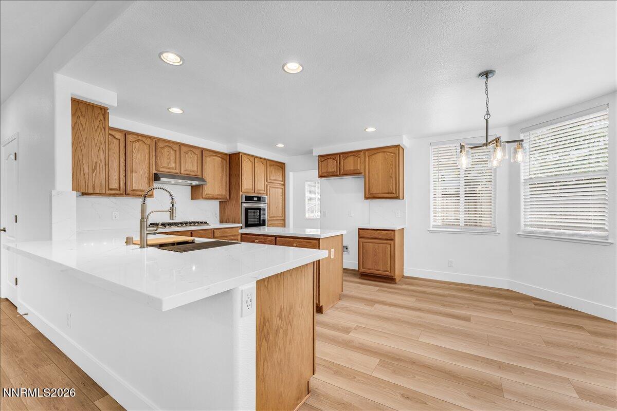2329 Red Maple Court Reno, NV 89523 - Photo 13 of 39 a kitchen with stainless steel appliances a stove top oven a sink a refrigerator and white cabinets