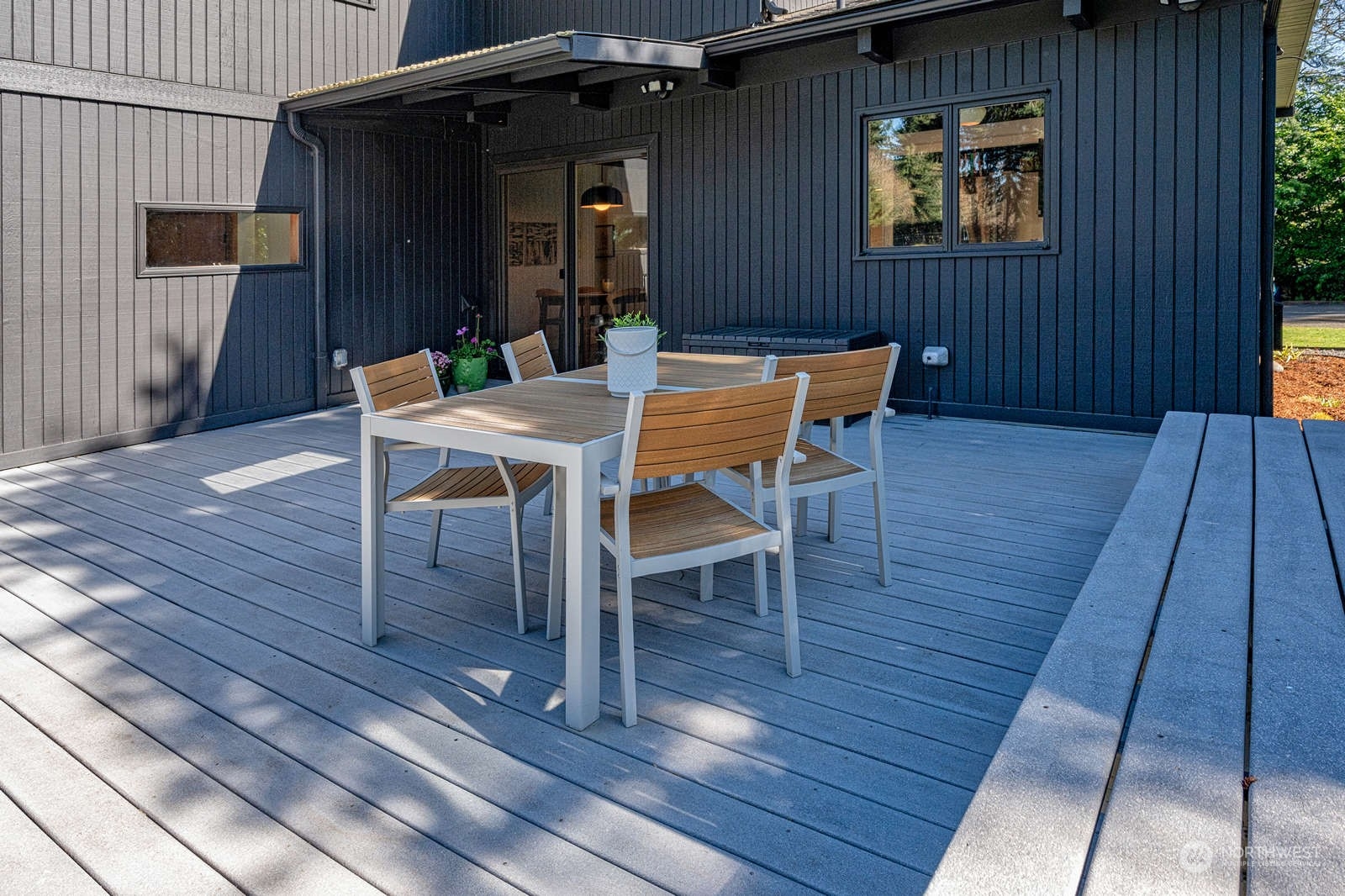 11907 103rd Avenue Southwest Vashon, WA 98070 - Photo 30 of 40 a view of a deck with table and chairs with wooden floor and a potted plant