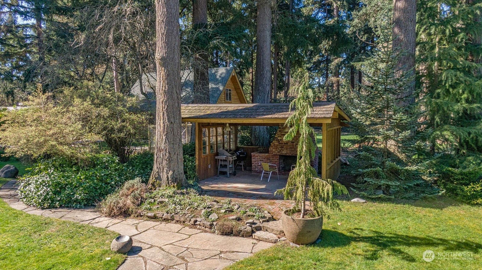 11907 103rd Avenue Southwest Vashon, WA 98070 - Photo 35 of 40 a view of a patio with table and chairs potted plants and large tree
