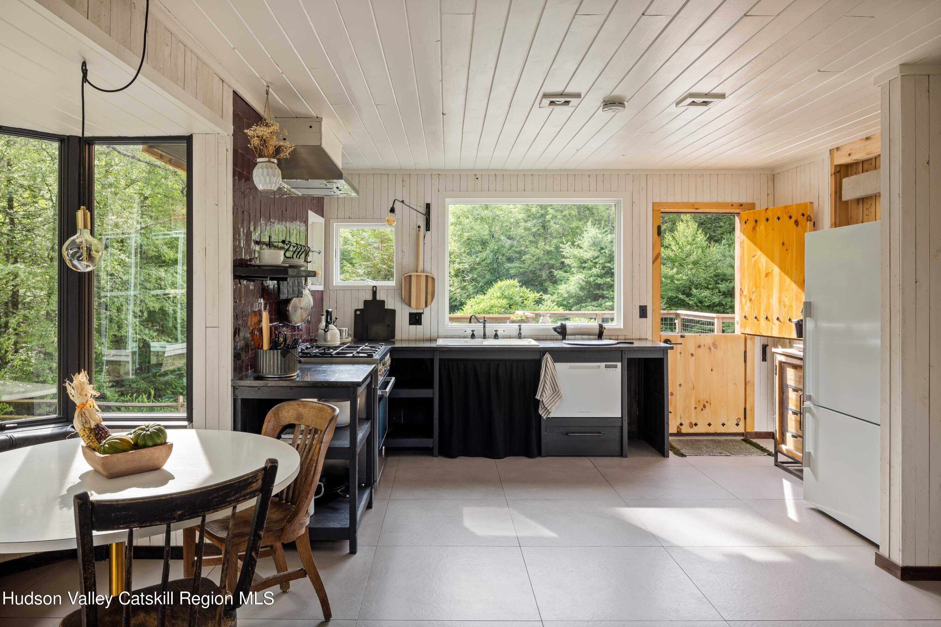 193 Cantine Road Kingston, NY 12401 - Photo 14 of 36 a kitchen with a stove a sink a refrigerator and a dining table
