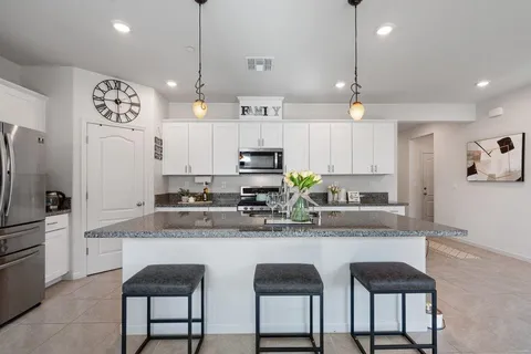 a kitchen with kitchen island granite countertop a table and chairs in it