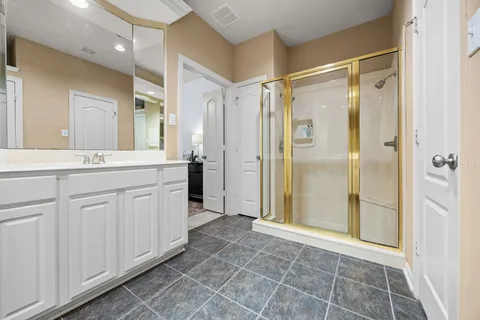 a bathroom with a shower sink and mirror