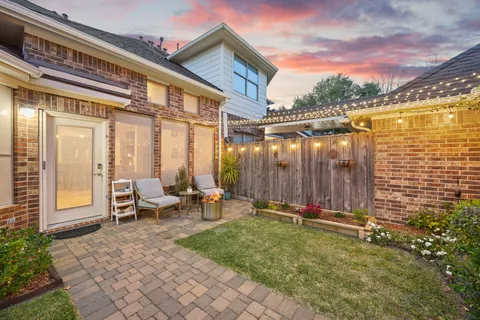 a backyard of a house with table and chairs