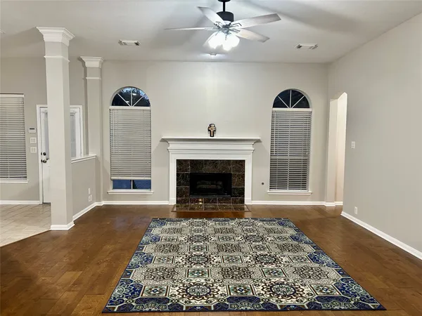 a view of a livingroom with a fireplace a rug and a large window