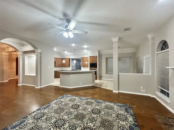 a view of a kitchen with kitchen island wooden floor and a ceiling fan