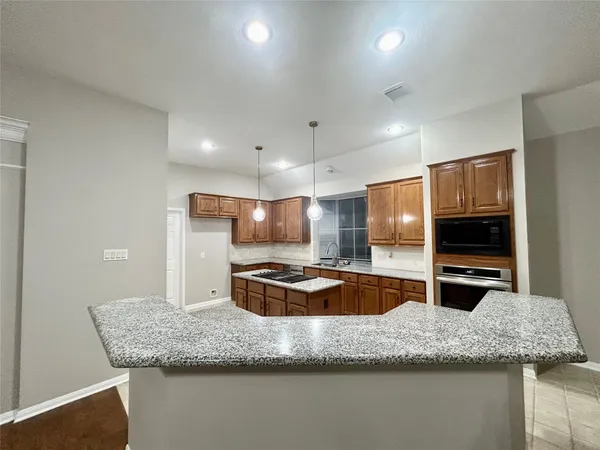 a kitchen with stainless steel appliances granite countertop a sink and a refrigerator
