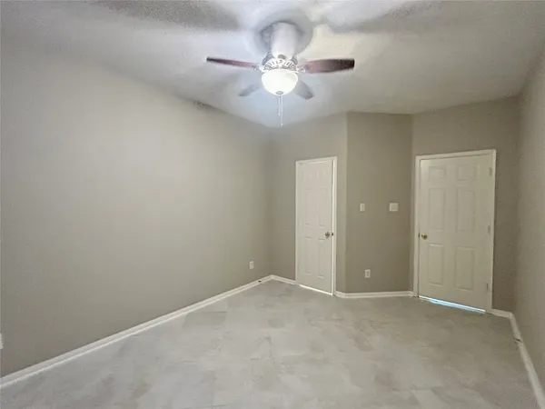 a view of an empty room with a ceiling fan