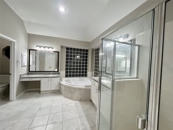 a bathroom with a tub sink and mirror