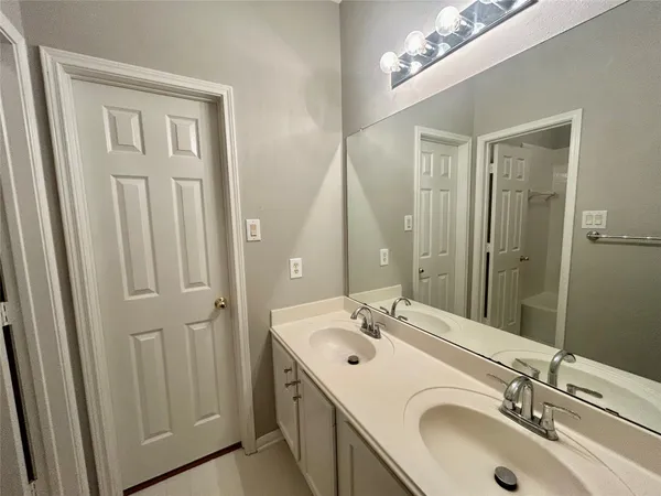 a bathroom with a double vanity sink and a mirror