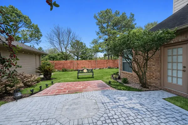 a view of a backyard with potted plants and large trees