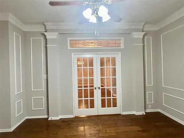a view of a bedroom with wooden floor and windows