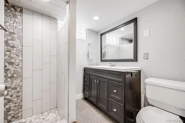 a bathroom with a toilet a sink and mirror