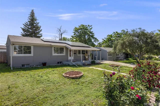 a view of a house with backyard and sitting area