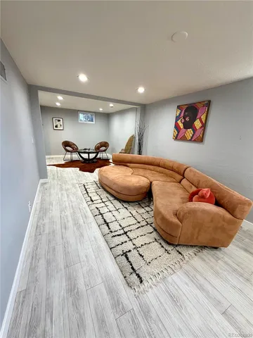a living room with furniture and a wooden floor