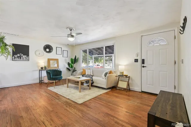 a living room with furniture two window and wooden floor