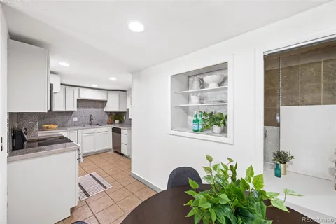 a kitchen with stainless steel appliances a white table a stove a microwave and cabinets