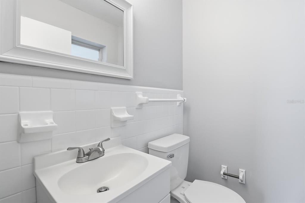 6832 Treehaven Drive Spring Hill, FL 34606 - Photo 13 of 29 a white toilet sitting next to a bathroom sink