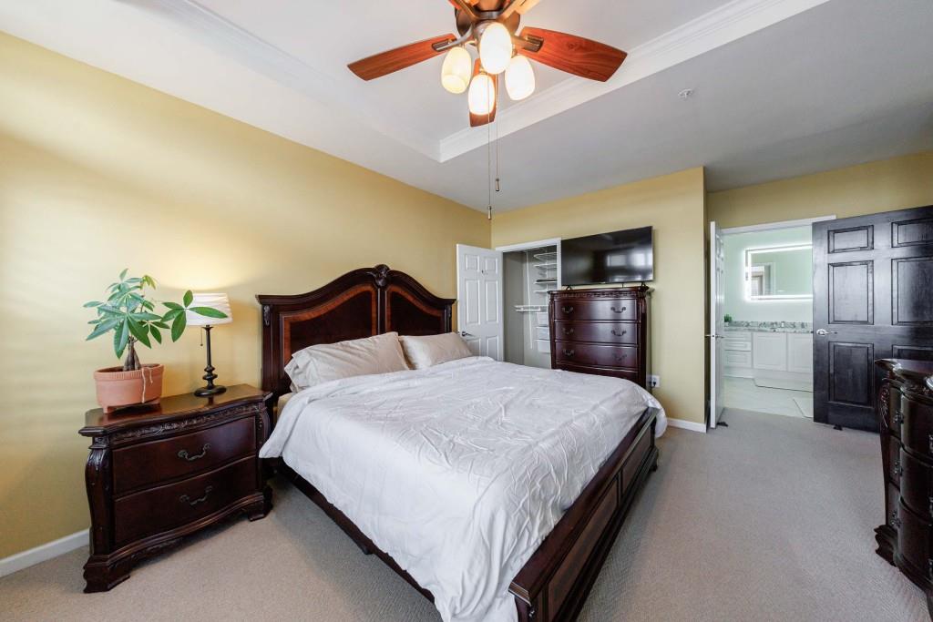 3334 Peachtree Road Northeast, Unit 1506 Atlanta, GA 30326 - Photo 13 of 51 a bedroom with a bed and a chandelier