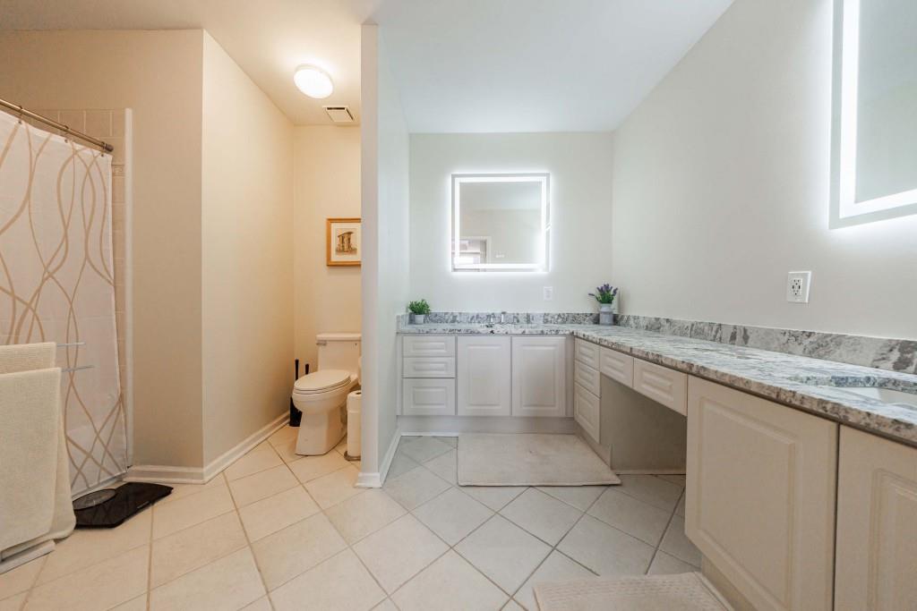 3334 Peachtree Road Northeast, Unit 1506 Atlanta, GA 30326 - Photo 17 of 51 a spacious bathroom with a granite countertop sink a toilet and a mirror