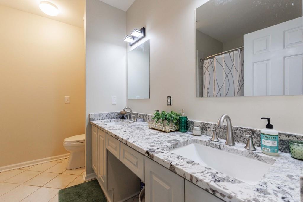 3334 Peachtree Road Northeast, Unit 1506 Atlanta, GA 30326 - Photo 22 of 51 a bathroom with a granite countertop sink a toilet and a mirror