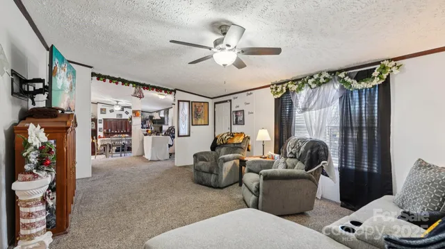 a living room with furniture a ceiling fan and a window