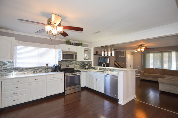720 Durham Lane Hoffman Estates, IL 60169 - Photo 9 of 34 a kitchen with kitchen island granite countertop a sink a stove and wooden floors