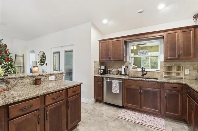 a kitchen with granite countertop a sink and cabinets