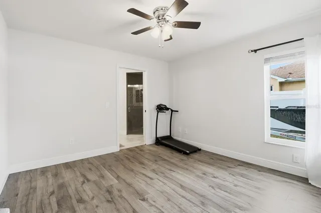 a view of a room with wooden floor and a ceiling fan