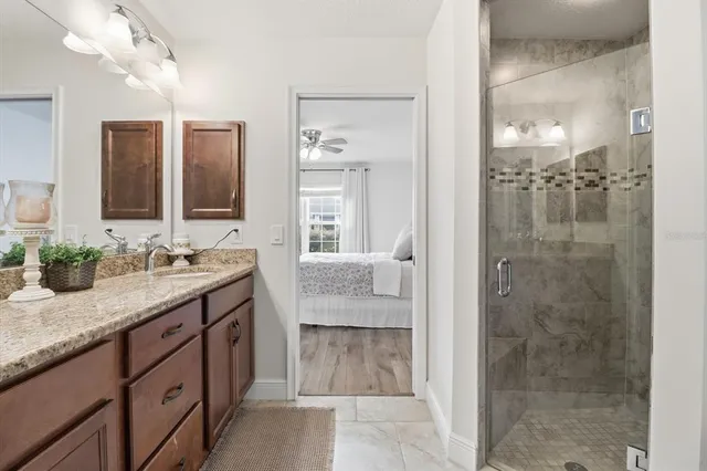 a bathroom with a granite countertop sink mirror and shower