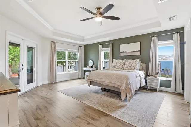 a spacious bedroom with a large bed and a chandelier fan