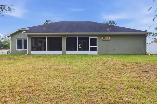 a view of a house with a yard and potted plants