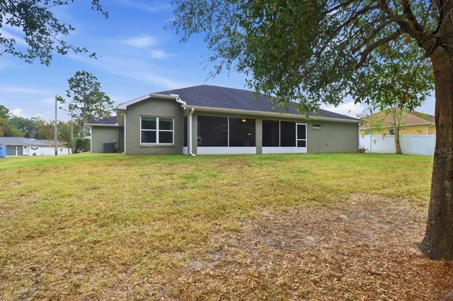a view of a house with a yard and tree