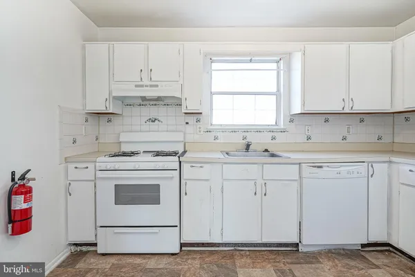 a kitchen with cabinets appliances a sink and a window