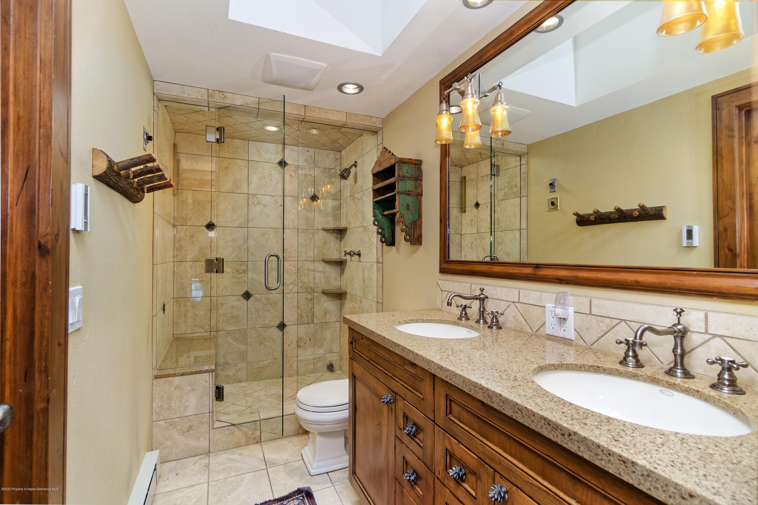 800 Ridge Road, Unit 14 Snowmass Village, CO 81615 - Photo 4 of 20 a bathroom with a granite countertop sink toilet and shower